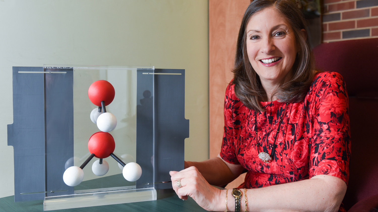 Maria Oliver-Hoyo next to a molecule reproduction