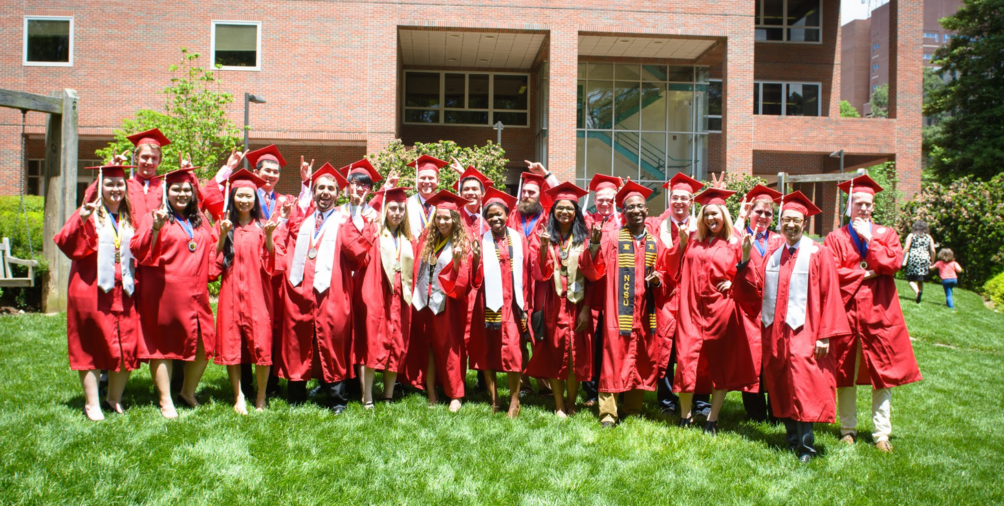 Graduate students in red caps and gowns