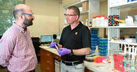 Michael Bereman and David Muddiman conversing in the lab