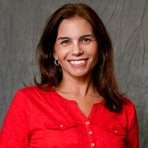 A female person smiling wearing a red shirt