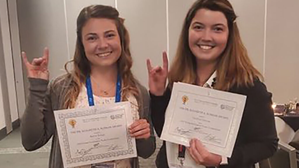 Hailey Young and Carolynn Davern holding Poster Awards during APS 2022