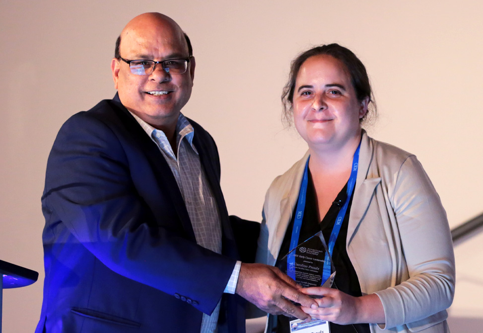 Caroline Proulx receiving the Early Career Lectureship Award from Doctor Ved Srivastava, President of the APS