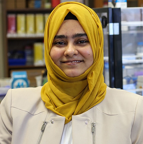 Headshot of a smiling young woman with a yellow scarf