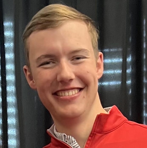 Headshot of a smiling young man wearing a red shirt