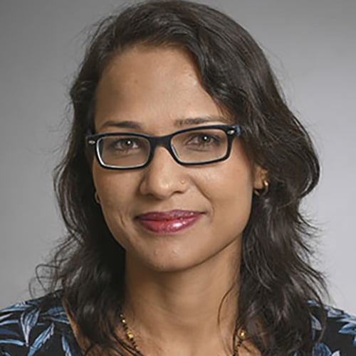 Headshot of a young woman wearing black framed eyeglasses