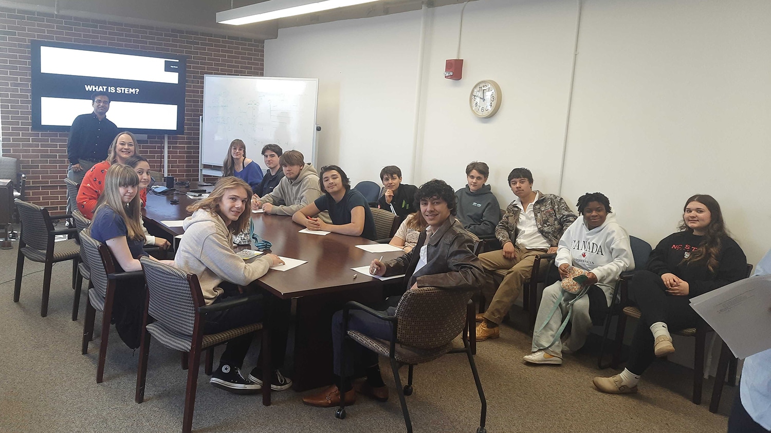 A group of students around a conference table