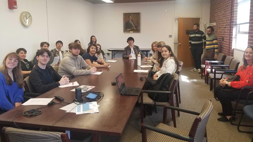 A group of students around a conference table
