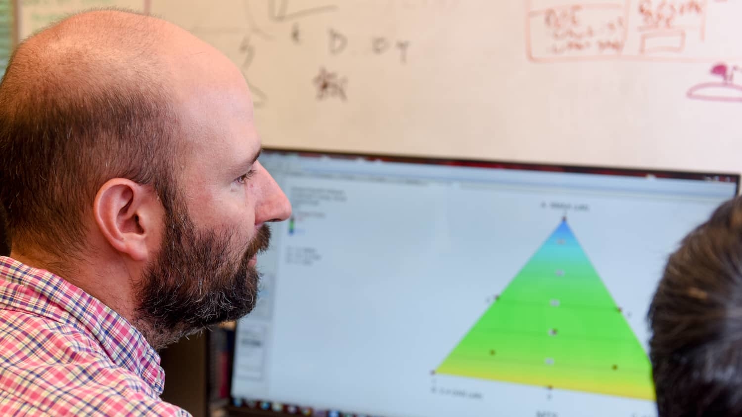 Michael Bereman supervising a student's work on the computer