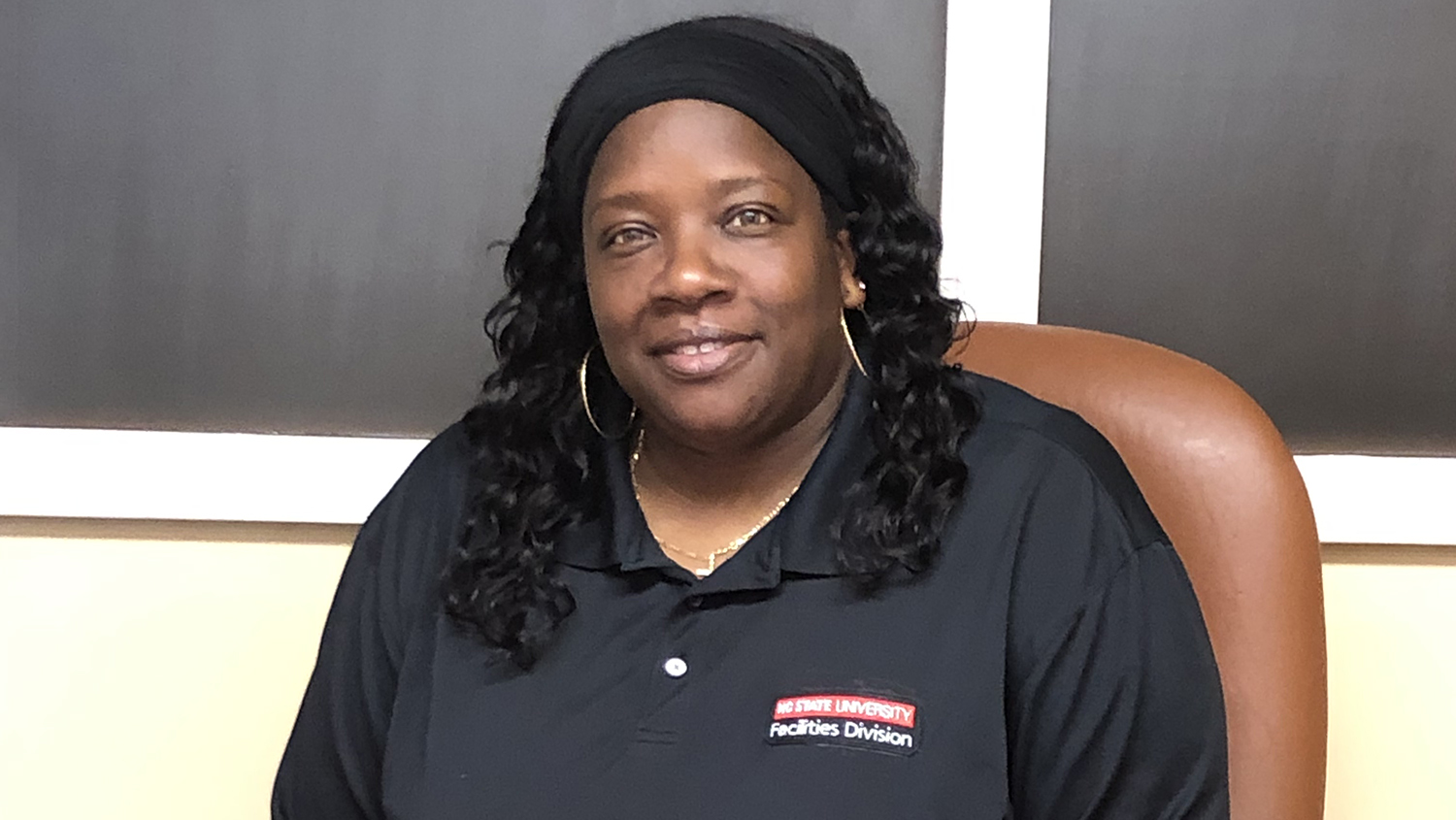 A person with long black hair wearing earrings