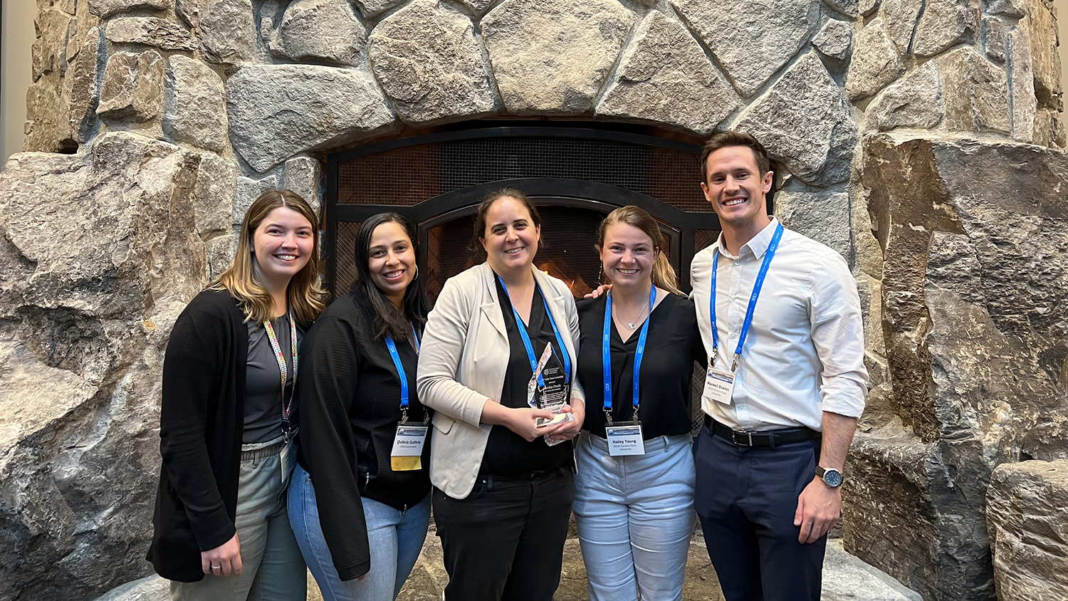 An outdoor group photo of the Proulx Lab during APS 2022 including Quibria Guthrie, Hailey Young, Carolynn Davern, Max Bowles and Caroline Proulx