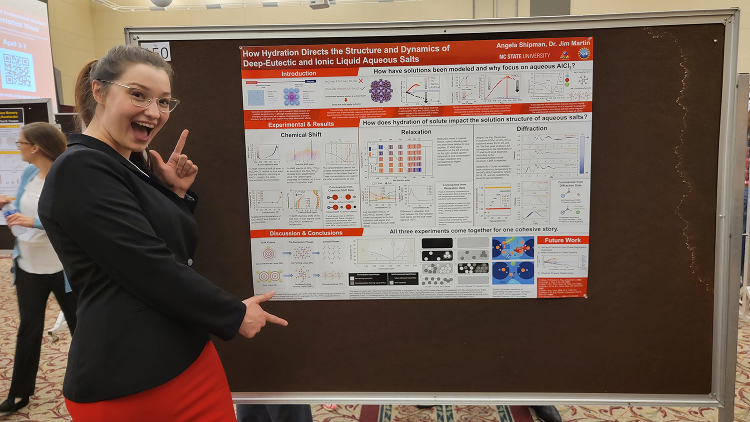 Angela Shipman pointing at her poster