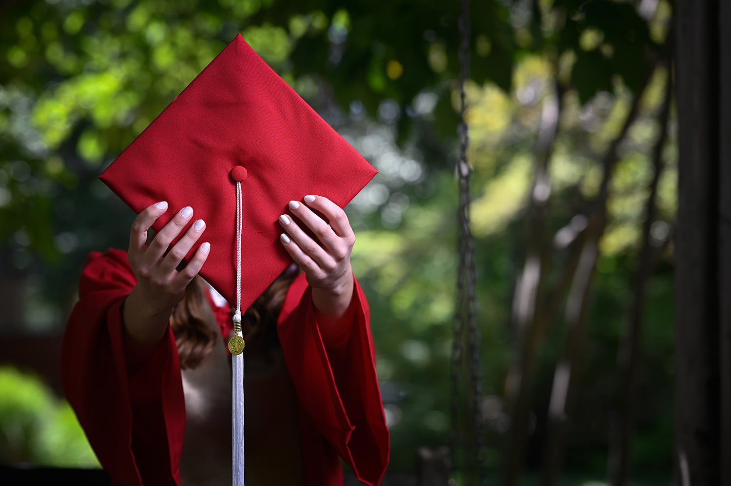 Student holding graduation cap in front of the camera
